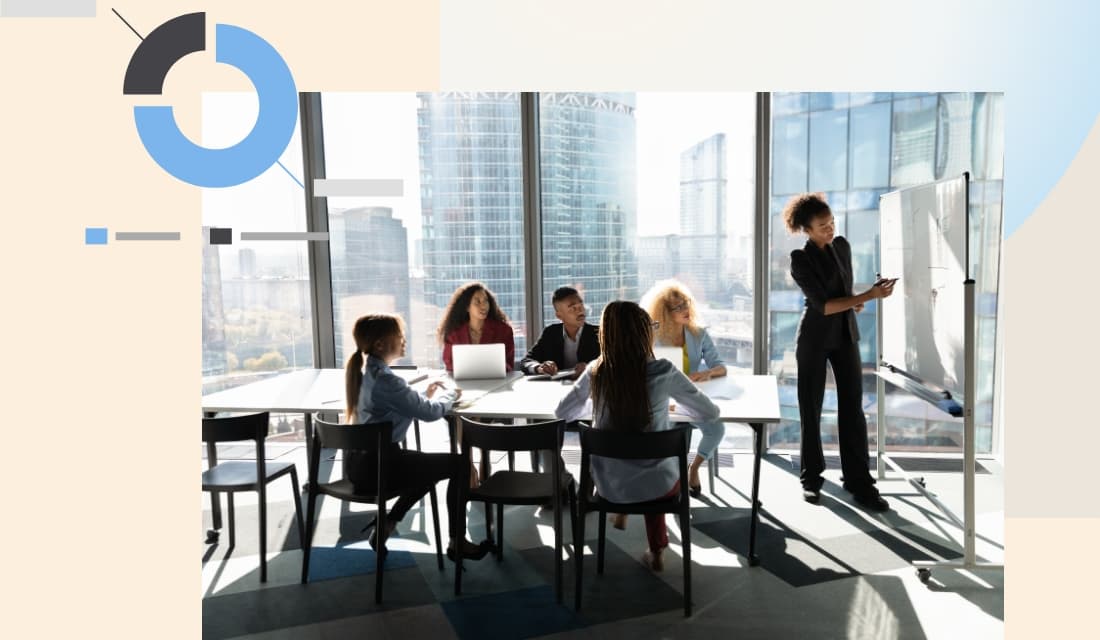 A meeting with 5 people sitting behind a table and 1 presenting