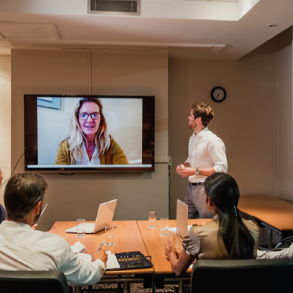 A hybrid meeting with three live participants and one on video call
