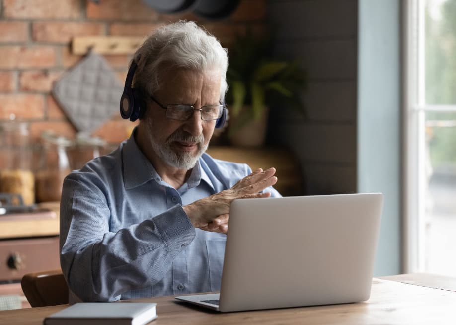 A serious man wearing headphones at a laptop